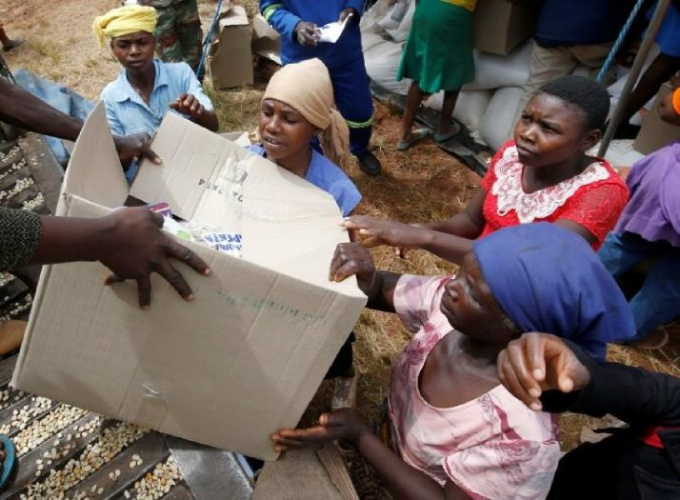Ngườì dân Zimbabwe nhận hàng cứu trợ từ tổ chức từ thiện tại thành phốChipinge. Ảnh: Reuters.