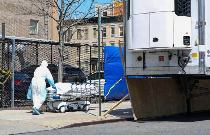 Nhân viên y tế vận chuyển thi thể bệnh nhân Covid-19 ra container chứa xác tại thành phố New York. Ảnh: Getty Images.