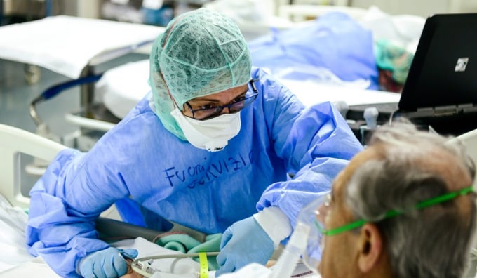 Một nhân viên y tế an ủi bệnh nhân bị nhiễm nCoV tại bệnh viện ở vùng Bergamo, Italia. Ảnh: AFP.