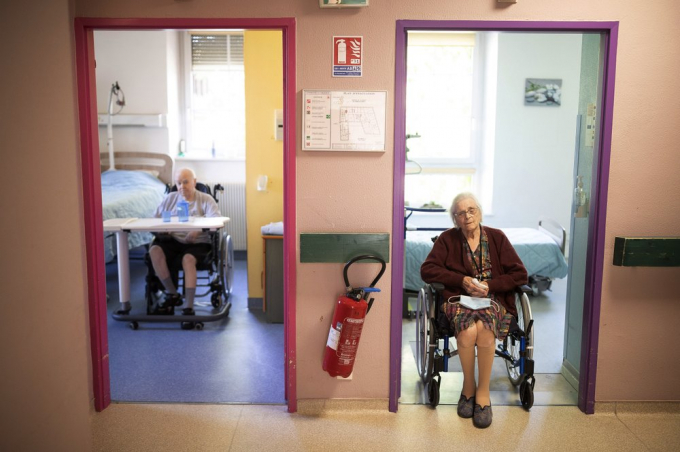 Marie Lithard, phải, và người hàng xóm Yves Chretien ngồi nhìn ra khỏi phòng của họ trong một viện dưỡng lão ở Ammerschwir, Pháp, hôm 16/4/2020. Ảnh: AP.