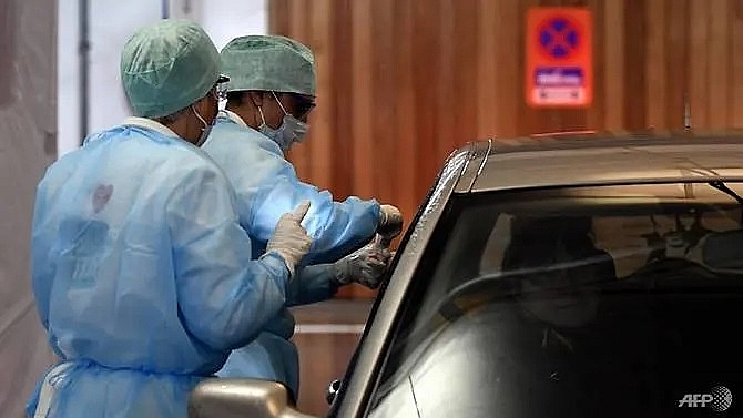 Nhân viên y tế lấy mẫu xét nghiệm Covid-19 cho tài xế ngay trong xe tại Liege, vào ngày 10/3/2020. Ảnh: AFP.