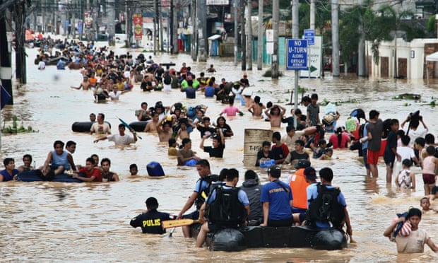 Người dân Philippines lội trong nước lũ sâu tới ngực ở vùng ngoại ô Cainta, phía đông Manila, vào năm 2009. Ảnh: AP.