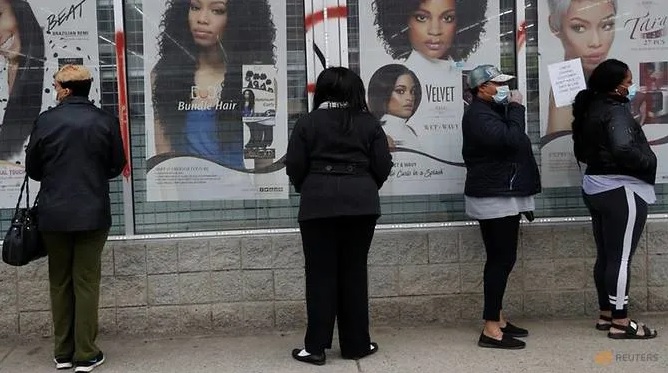 Mọi người đeo khẩu trang chờ đợi bên ngoài một thẩm mỹ viện trong khu vực Highland Park của Detroit, Michigan. Ảnh: Reuters.
