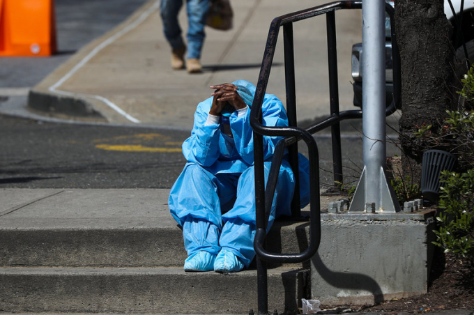 Quá mệt mỏi, một nhân viên y tế Bệnh viện Brooklyn (Mỹ) gục đầu nghỉ ngay ngoài sân sau ca làm 12 tiếng liên tục. Ảnh: Getty Images.