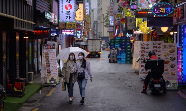 Hai người phụ nữ đeo khẩu trang đi bộ dọc theo một con hẻm ở Seoul, Hàn Quốc. Ảnh: Getty Images.