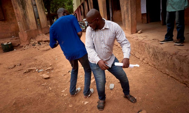 Hai người đàn ông ở Mali chào nhau kiểu 'chạm mông, không chạm tay' để ngăn chặn sự lây lan của Covid-19, ngày 29/3/2020. Ảnh: Getty Images.