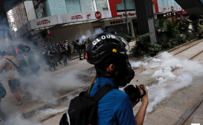 Cảnh sát chống bạo động bắn đạn hơi cay để giải tán những người biểu tình Hồng Kông. Ảnh: Reuters.