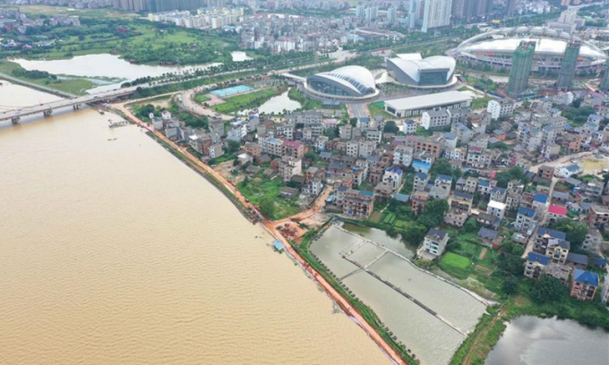 Ảnh chụp trên không ngày 11/7 cho thấy người dân gia cố đê chống thấm tạm thời để ngăn chặn lũ lụt tại làng Jiangjialing ở huyện Poyang, phía đông tỉnh Giang Tây của Trung Quốc. Ảnh: Tân Hoa Xã.