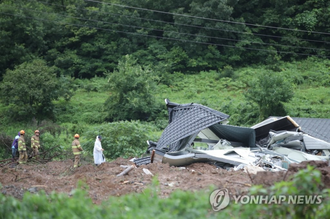 Các nhân viên cứu hộ tìm kiếm một người bị mắc kẹt trong đống đổ nát của trận lở đất tại một ngôi làng ở Gokseong, cách Seoul khoảng 400 km về phía nam, ngày 8/8/2020. Bốn người đã chết và một người mất tích sau trận lở đất do mưa lớn. Ảnh: Yonhap.