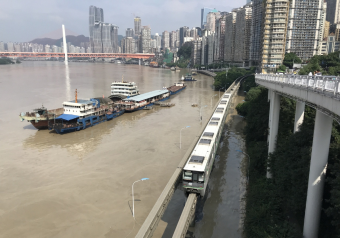 Dòng nước lũ đục ngầu bên dưới một đoàn tàu đường sắt thành phố ở Trùng Khánh hôm 19/8/2020. Ảnh: China Daily.