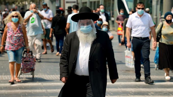 Một người đàn ông được nhìn thấy đeo khẩu trang và khiên bảo vệ ngăn giọt bắn ở Jerusalem. Ảnh: Sky News.