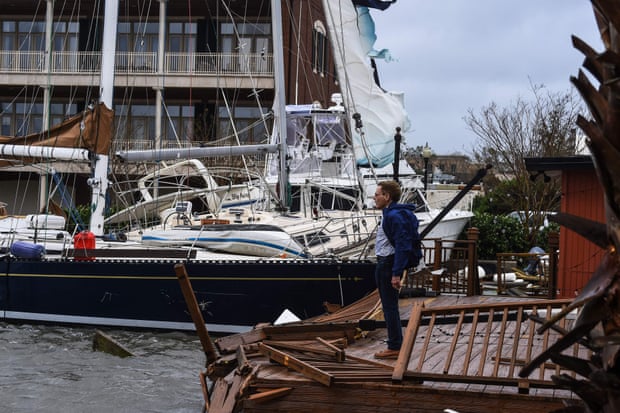 Một người đàn ông đứng trên bến tàu, trung tâm thành phố Pensacola, bị bão Sally xé nát để kiểm tra con thuyền của mình.