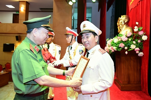 Bộ trưởng Công an Tô Lâm trao quyết định thăng cấp bậc hàm từ Thiếu tướng lên Trung tướng cho Thứ trưởng Trần Quốc Tỏ. Ảnh: Bộ Công an.