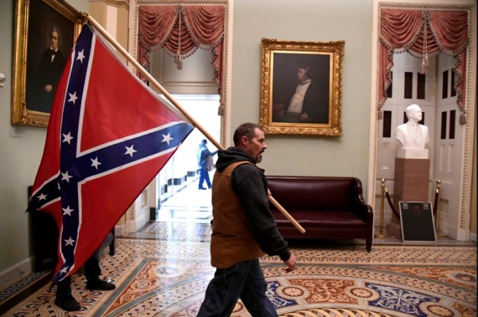 Một người ủng hộ Tổng thống Donald Trump mang cờ Liên minh vào tòa nhà Quốc hội Hoa Kỳ, ngày 6/1/2021. Ảnh: Reuters.