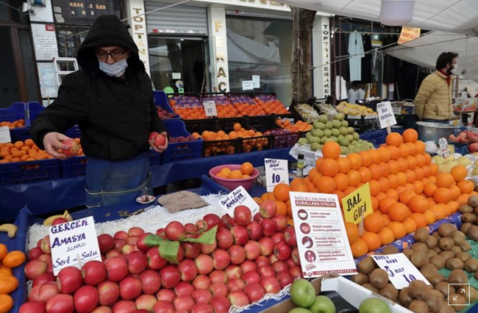 Seref Geyik (53 tuổi), tranh thủ sắp xếp lại quầy hàng trong khi chờ khách tại một khu chợ địa phương ở quận Fatih, Istanbul (Thổ Nhĩ Kỳ), ngày 13/1/2021. Ảnh: Reuters.