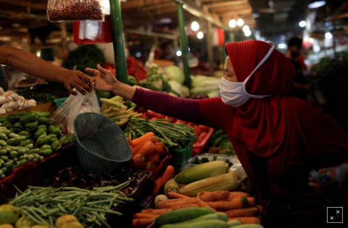 Người phụ nữ đeo khẩu trang bán rau tại chợ truyền thống khi dịch bệnh Covid-19 tiếp tục bùng phát, ở Jakarta, Indonesia, ngày 23/9/2020. Ảnh: Reuters.