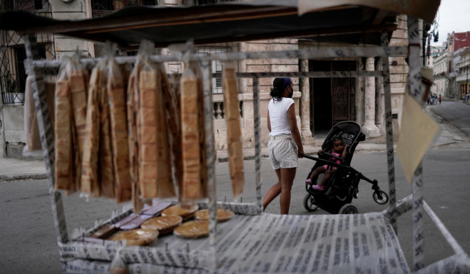 Một người phụ nữ đi ngang qua xe bán bánh quy ở trung tâm thành phố Havana, Cuba, ngày 18/5/2021. Ảnh: Reuters.