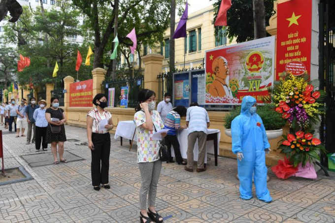Các quy định kiểm soát dịch được thực hiện nghiêm túc tại các điểm bỏ phiếu tại Hà Nội. Ảnh: AFP.