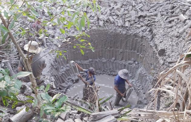 Farmers dig holes to build a biogas tank to treat pig waste. Photo: Minh Dam.
