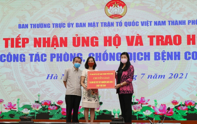Bà Nguyễn Lan Hương, Chủ tịch Ủy ban Mặt trận Tổ quốc Việt Nam TP Hà Nội trao chứng nhận tài trợ 100 nghìn kit test nhanh cho ông Đào Đình Khôi, Giám đốc Công ty TNHH Medicon.