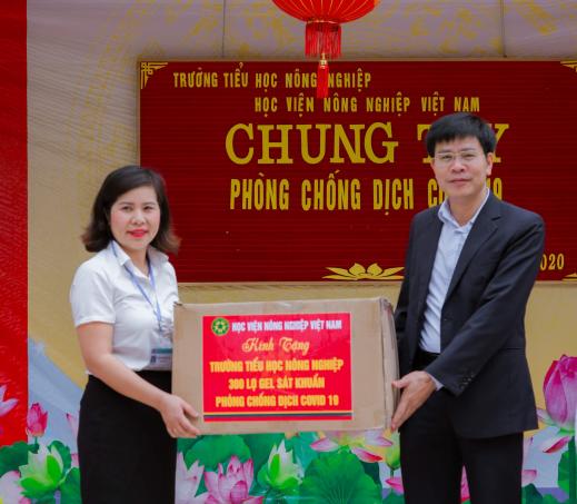 TS Nguyễn Tất Thắng, Chủ tịch Công đoàn Học viện Nông nghiệp Việt Nam trao tặng dung dịch sát khuẩn phòng chống dịch COVID-19 cho Trường Tiểu học Nông nghiệp. Ảnh: TL