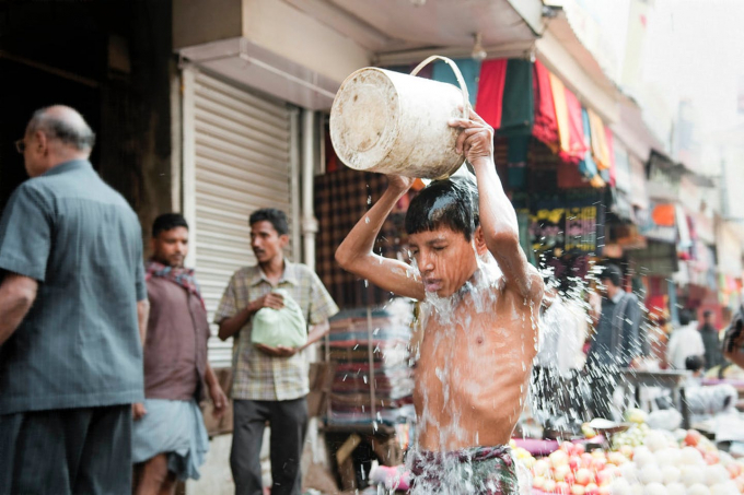 Ấn Độ vừa trải qua 1 thập niên nóng kỷ lục, riêng trong năm ngoái trực tiếp làm khoảng 350 người thiệt mạng. Trong ảnh, 1 cậu bé dội nước làm mát ngay trên đường phố Kolkata. Ảnh: Reuters.