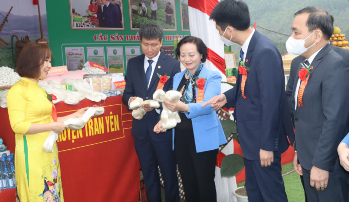 Bộ trưởng Phạm Thị Thanh Trà và lãnh đạo tỉnh Yên Bái xem mặt hàng tơ tằm - sản phẩm độc đáo của huyện Trấn Yên. Ảnh: Thái Sinh.