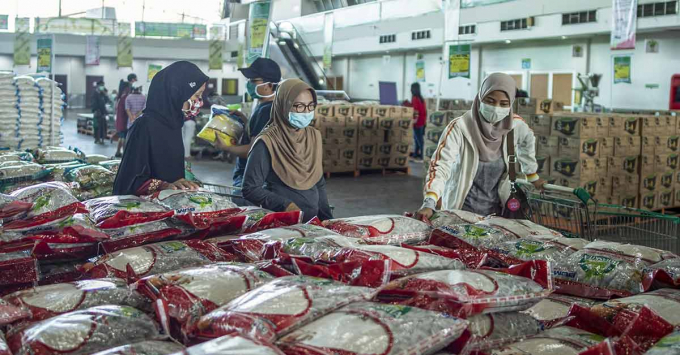 Người dân chọn mua gạo giá rẻ và các mặt hàng tạp hóa khác tại một nhà kho trong bối cảnh bùng phát dịch Covid-19, ở Surabaya, Đông Java, indonesia, ngày 22/4/2020. Ảnh: AFP.