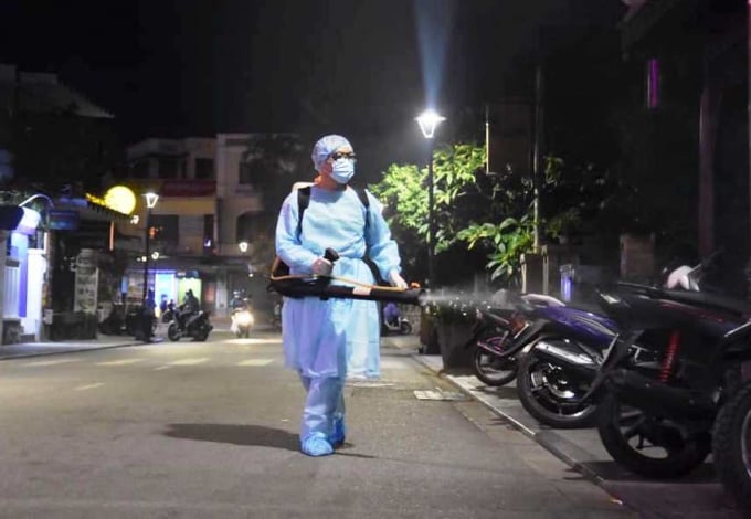 Nhân viên y tế Thừa Thiên- Huế đang phun khử trùng khu vực khách sạn nơi lưu trú của bệnh nhân người Anh. Ảnh: T.Q.