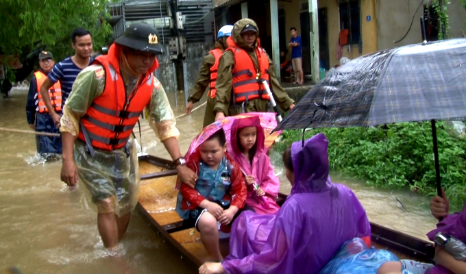 Lực lượng chức năng tiến hành di dời hàng chục hộ dân ra khỏi vùng ngập lụt. Ảnh: T.T.