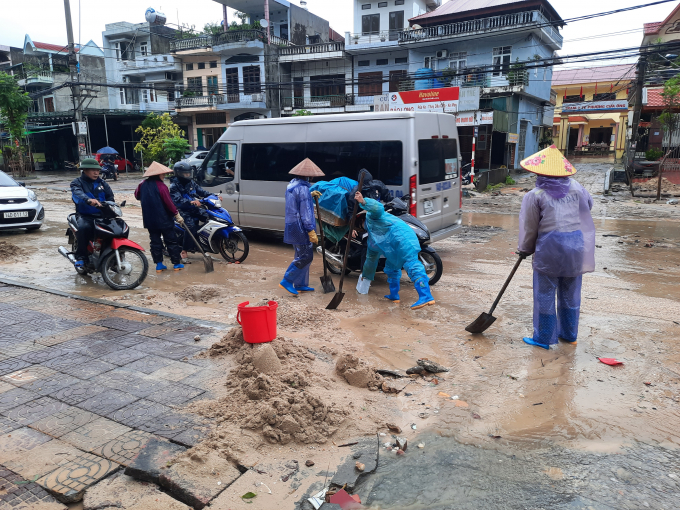Nhân viên môi trường đang tích cực dọn bùn đất trên đường.
