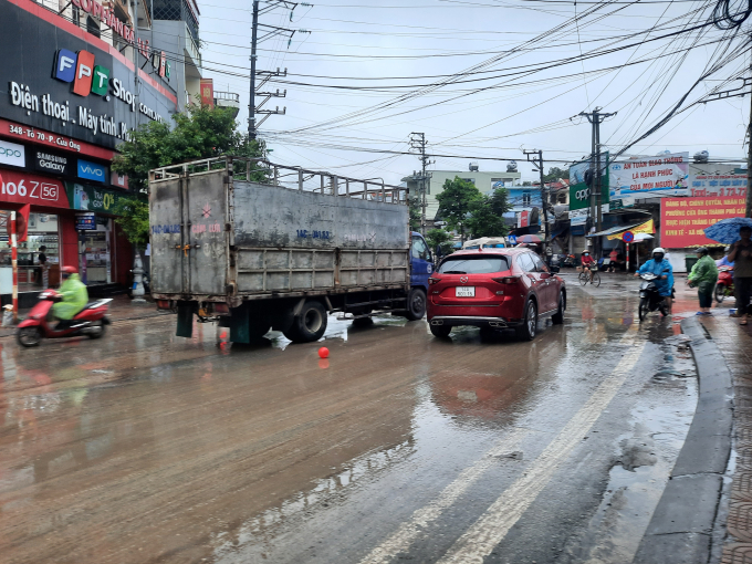 Chiếc xe tải bị chết máy do ngập nước ngay giữa ngã 3 Cửa Ông - Vân Đồn, gây khó khăn cho các phương tiện di chuyển trên đường. 