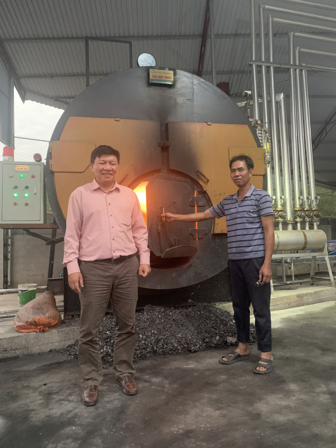 Mr. Nguyen Ton Quyen (left) introducing the boiler that keeps chickens warm in winter. Photo: Dinh Muoi.
