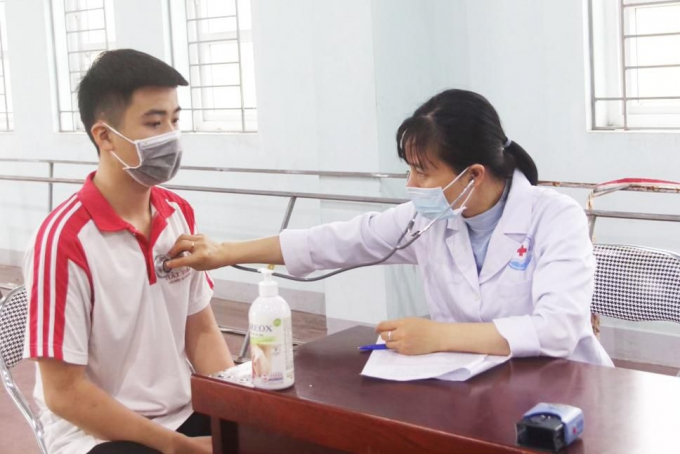 Khám sàng lọc cho các đối tượng là học sinh THCS, THPT trước khi tiến hành tiêm chủng. Ảnh: QMG