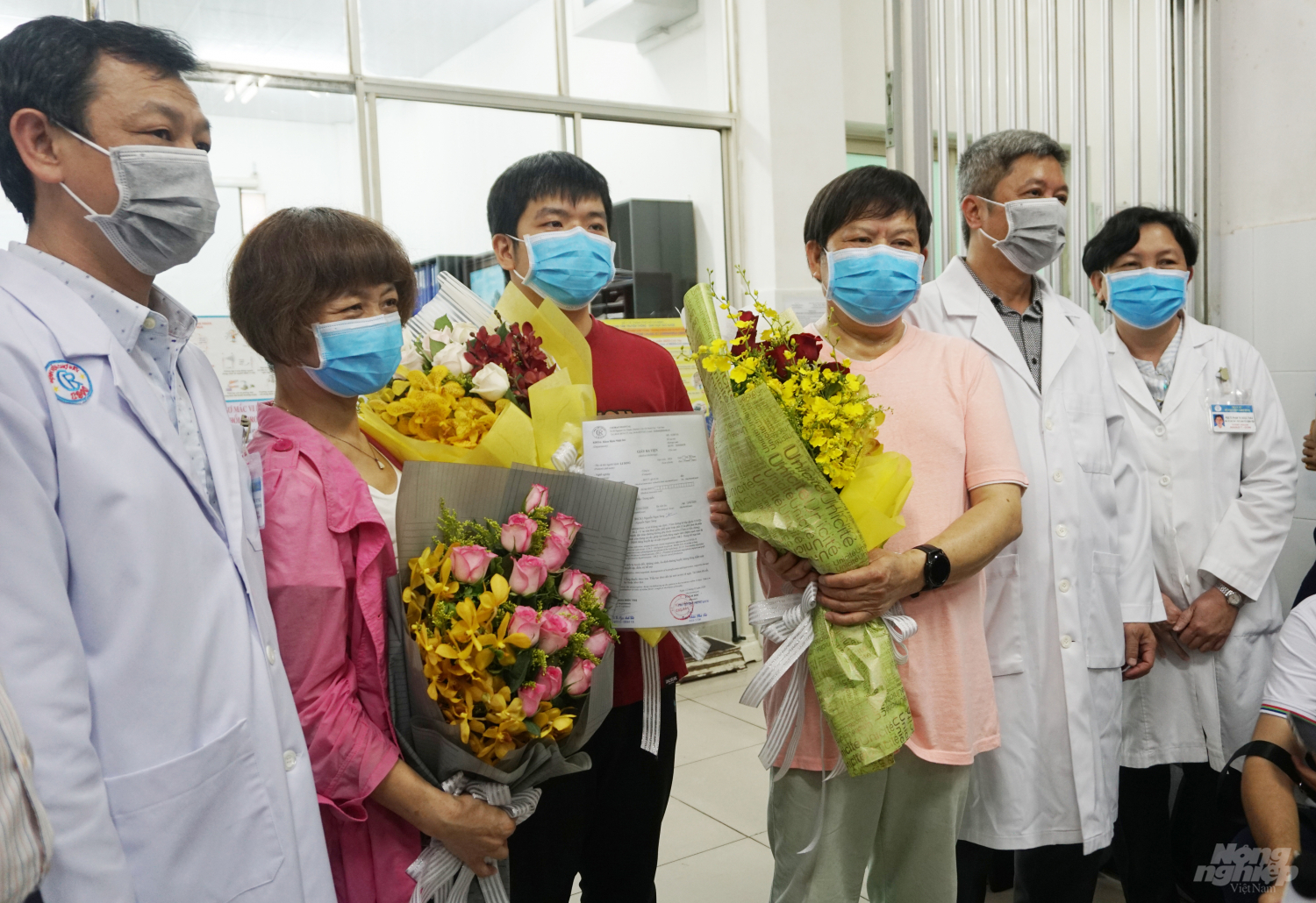 Thứ trưởng Bộ Y tế Nguyễn Trường Sơn trao giấy ra viện cho bệnh nhân Li Ding. Ảnh: Nguyễn Thủy.