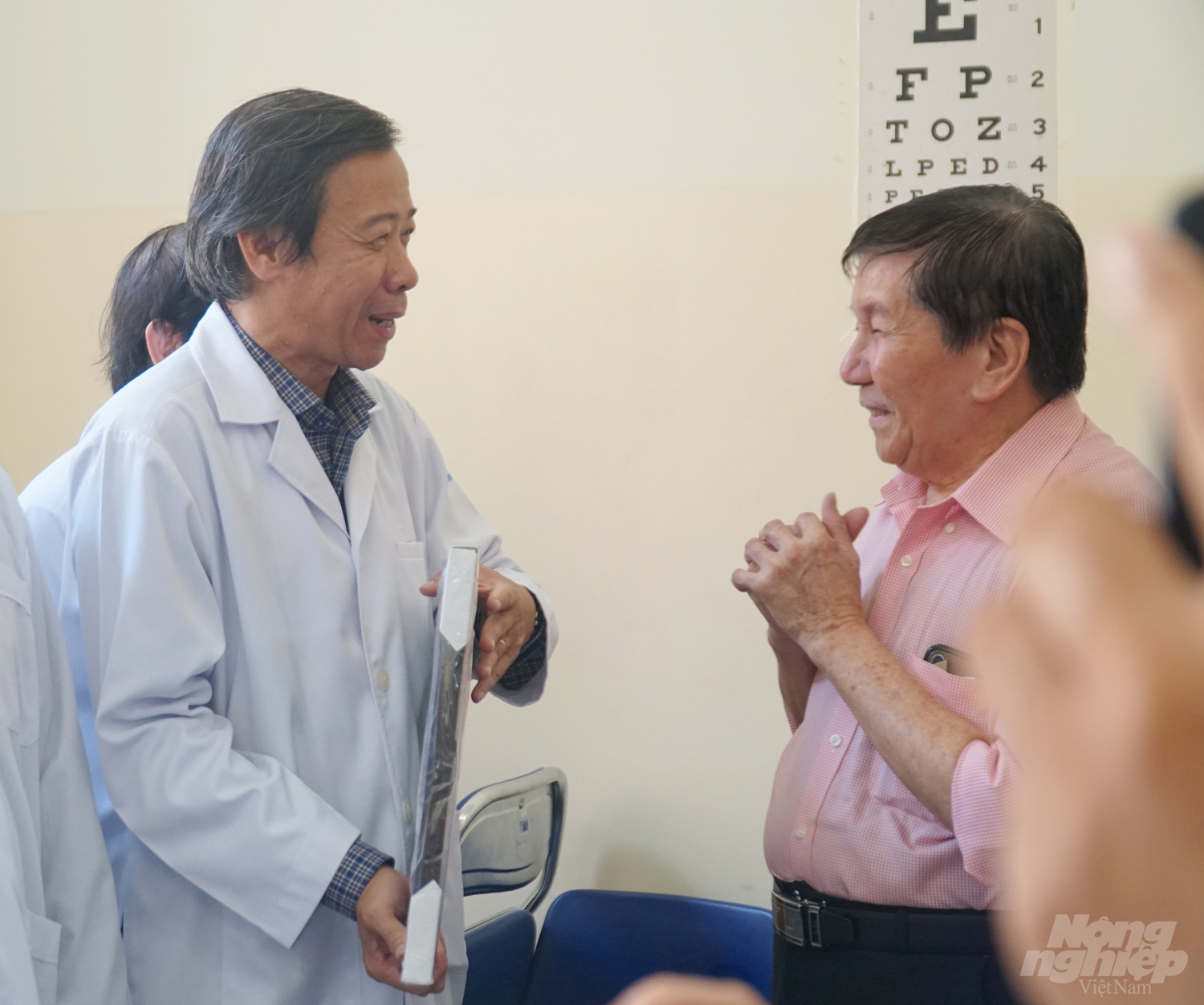 Ông T.K.H xúc động khi được Giám đốc Bệnh viện Bệnh Nhiệt đới tặng bức hình Bệnh viện làm kỷ niệm sau 21 ngày ông được điều trị tại đây. Ảnh: Nguyễn Thủy.
