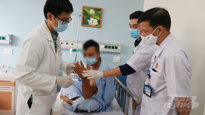 Các bác sĩ thăm khám trực tiếp cho bệnh nhân, cánh tay đang phục hồi dần. Ảnh: Nguyễn Thủy.