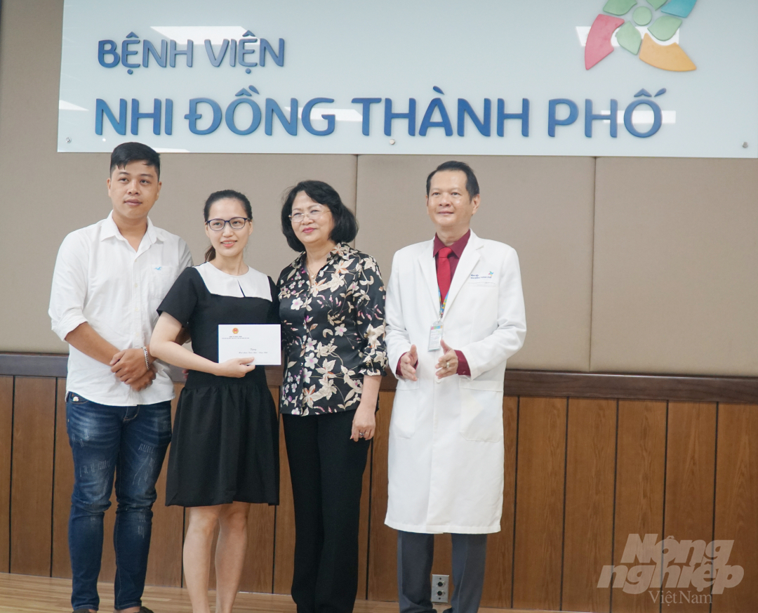Cha mẹ Trúc Nhi - Diệu Nhi nhận quà từ Phó Chủ tịch nước Đặng Thị Ngọc Thịnh. Ảnh: Nguyễn Thủy.
