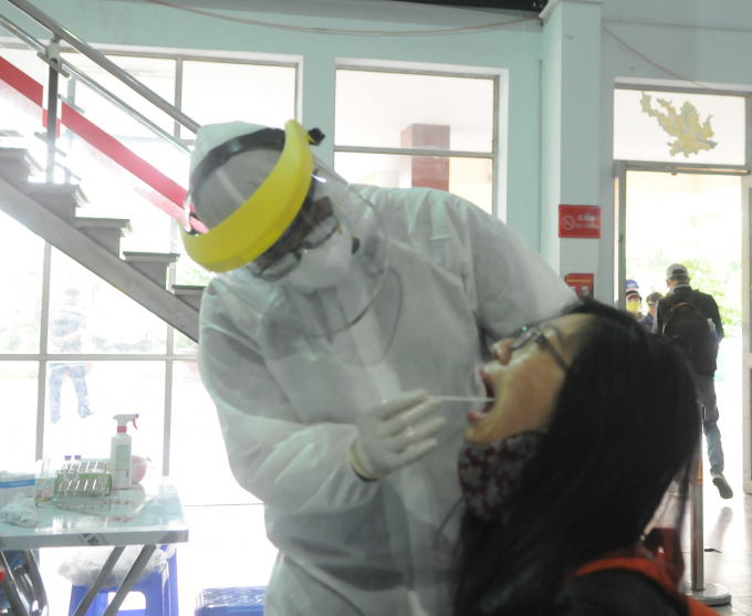 Lấy mẫu phết họng để xét nghiệm virus SARS-CoV-2 tại ga Sài Gòn. Ảnh: Linh Linh.