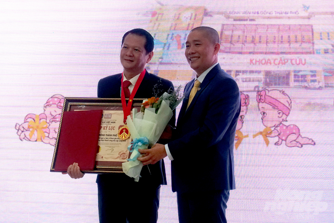 TS.BS Trương Quang Định - Giám đốc Bệnh viện Nhi đồng Thành phố thay mặt ê-kíp phẫu thuật nhận quyết định, bằng khen và 1 huy hiệu xác lập Kỷ lục Việt Nam.