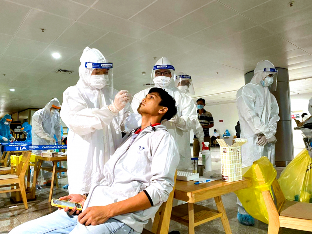 Thực hiện lấy mẫu xét nghiệm SARS-CoV-2 nhân viên tại sân bay Tân Sơn Nhất đêm 6/2. Ảnh: CTV.