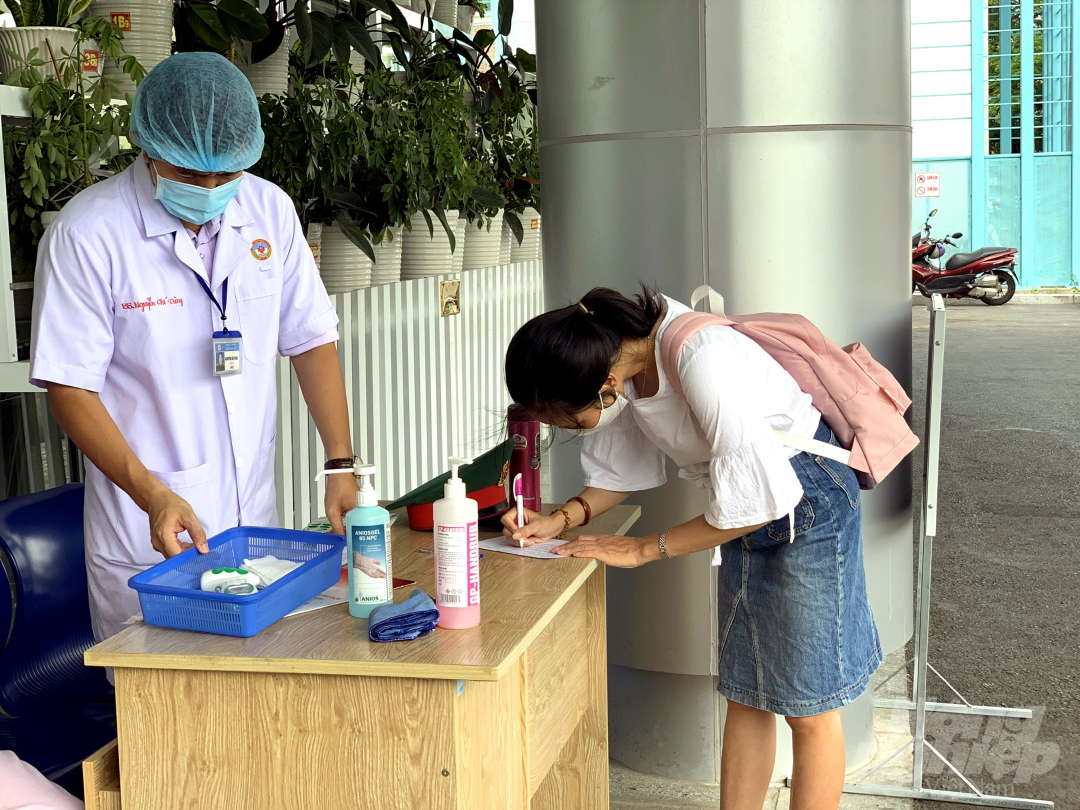 Thực hiện khai báo y tế ngay phía ngoài cửa khu khám bệnh của Bệnh viện Quân y 175. Ảnh: Nguyễn Thủy.