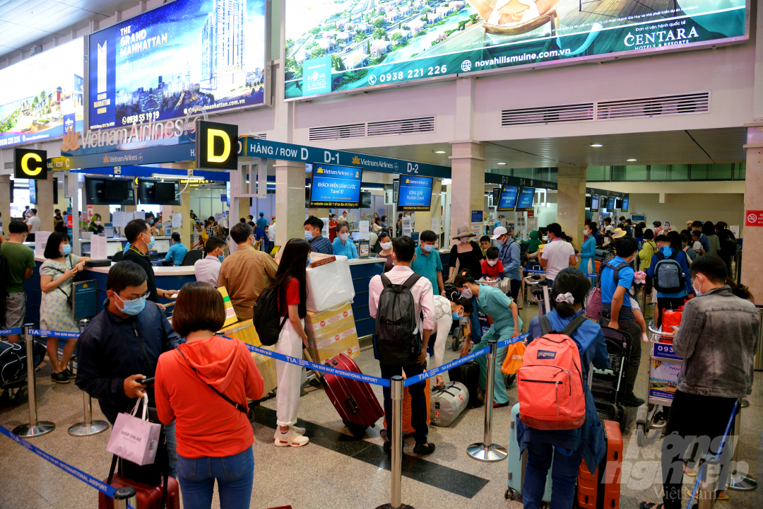 Người dân làm thủ tục để về quê đón Tết tại ga quốc nội sân bay Tân Sơn Nhất. Ảnh: Luynh Biển.