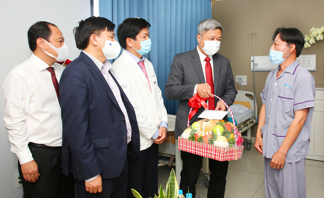 Thứ trưởng Nguyễn Trường Sơn thay mặt Bộ y tế thăm, tặng quà cho bệnh nhân Lê Văn Mến. Ảnh: Bệnh viện cung cấp.