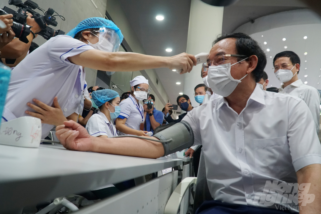 Nhân viên y tế đo nhiệt độ, huyết áp cho Bí thư Thành ủy TP.HCM Nguyễn Văn Nên. Ảnh: Nguyễn Thủy.