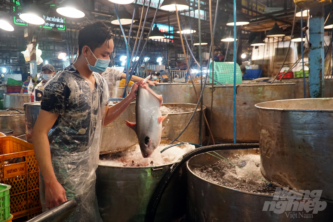 Các thương nhân tại Chợ Đầu mối nông sản thực phẩm Bình Điền thực hiện vận chuyển hàng hóa ra khỏi khu vực chợ chậm nhất là 20 giờ ngày 6/7. Ảnh: Nguyễn Thủy.