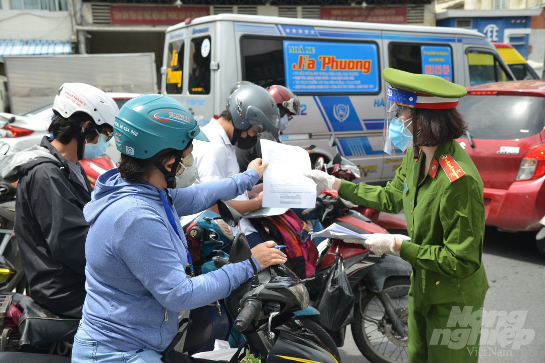 Người dân di chuyển trên đường trong thời gian TP.HCM thực hiện giãn cách xã hội phải có giấy tờ của cơ quan đơn vị, xác nhận thuộc đối tượng được di chuyển. Ảnh: Luynh Biển.