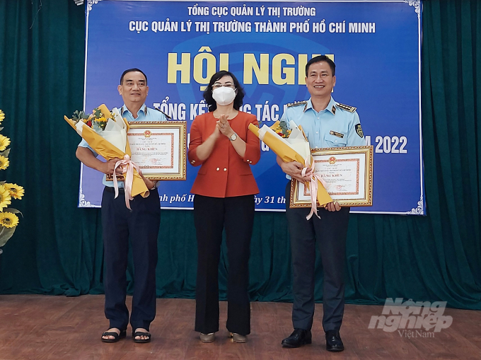 Bà Phan Thị Thắng, Phó Chủ tịch UBND TP.HCM tặng bằng khen của UBND TP.HCM cho tập thể/cá nhân Cục Quản lý thị trường TP.HCM đã có thành tích xuất sắc trong năm 2021. Ảnh: Nguyễn Thủy.