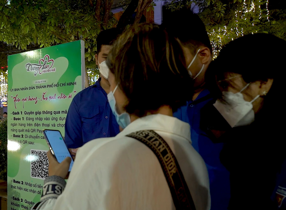 Người dân đến thăm quan thưởng lãm Đường hoa Nguyễn Huệ quyên góp tiền thông qua mã QR.