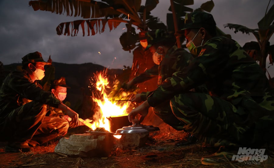 Tổ công tác tại mốc 112 tranh thủ trao đổi tình hình trong bữa cơm tối tại lều dã chiến. Ảnh: Mạnh Dũng. 